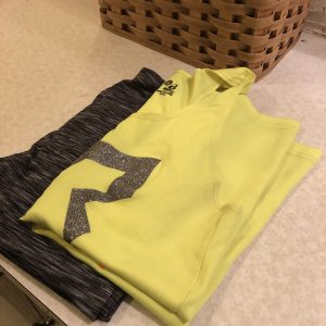 A pair of workout clothes laid out on a bathroom sink