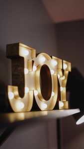 A light up sign that says JOY