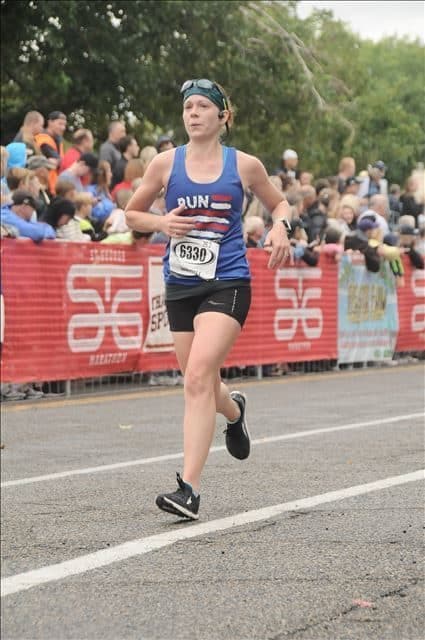 Gabe Cox running the St. George Marathon in a blue tank top and black running shorts