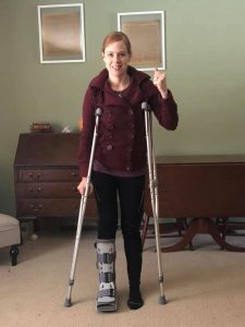 A woman using crutches while wearing a cast on her right leg