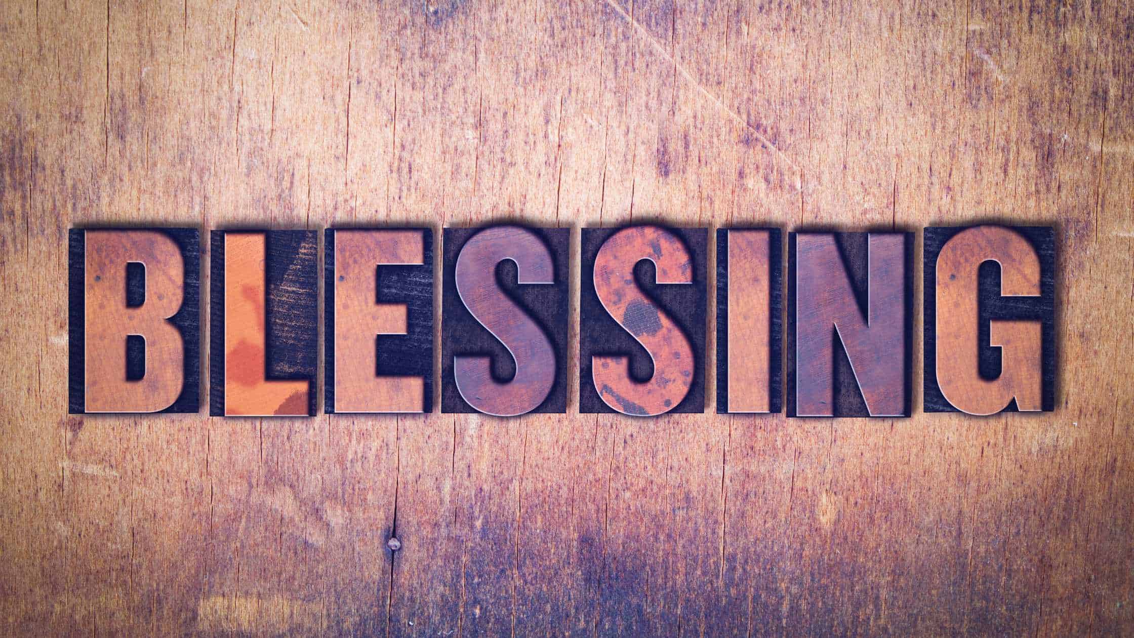 Letter blocks on a wooden wall that say blessing