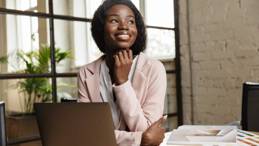 Woman sitting at computer looking away and smiling