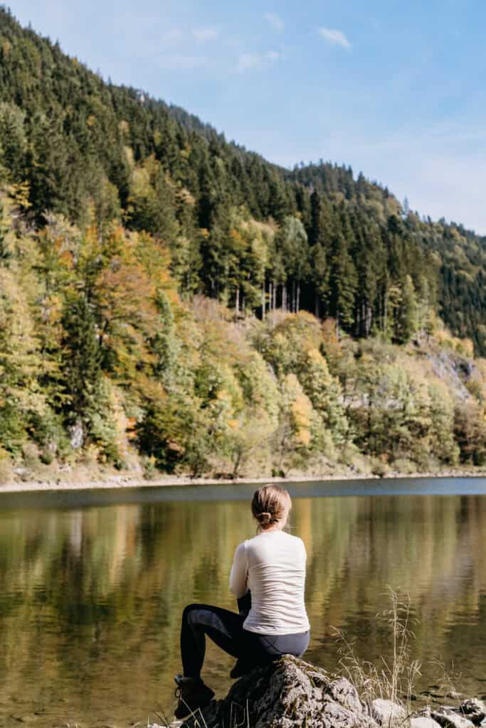 What to do when you lose your passion. Woman sitting and looking at the river and mountains.