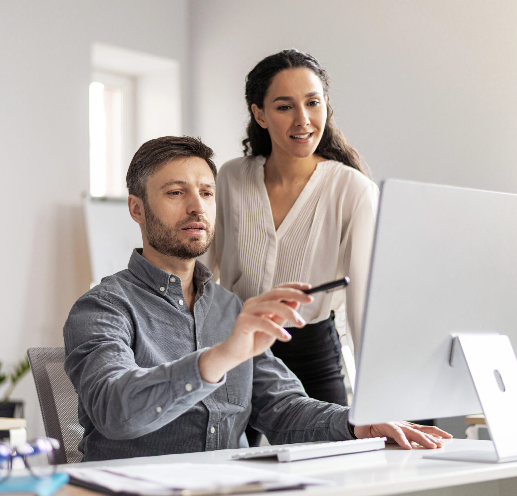 Man working with woman at the computer and pointing